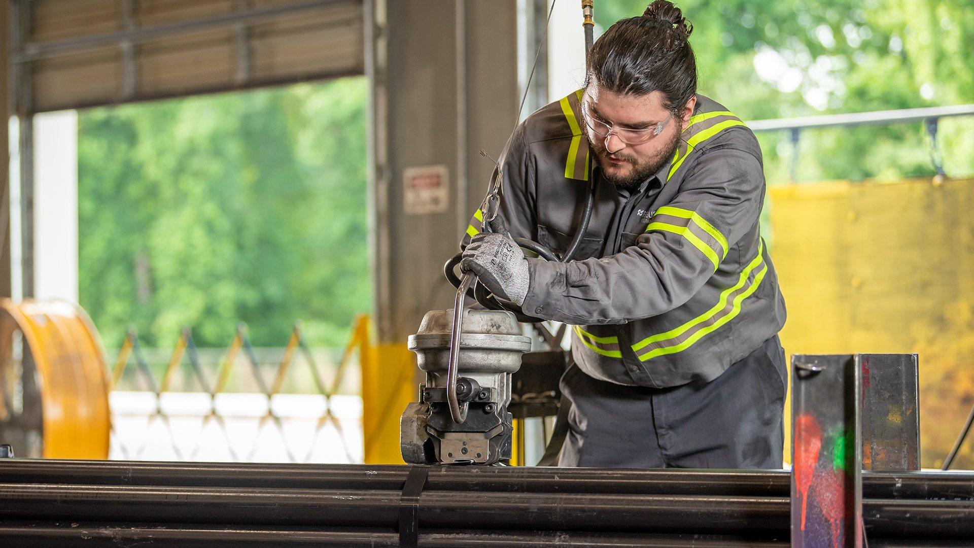 A Ferguson associate bundles fire protection pipe in a warehouse.